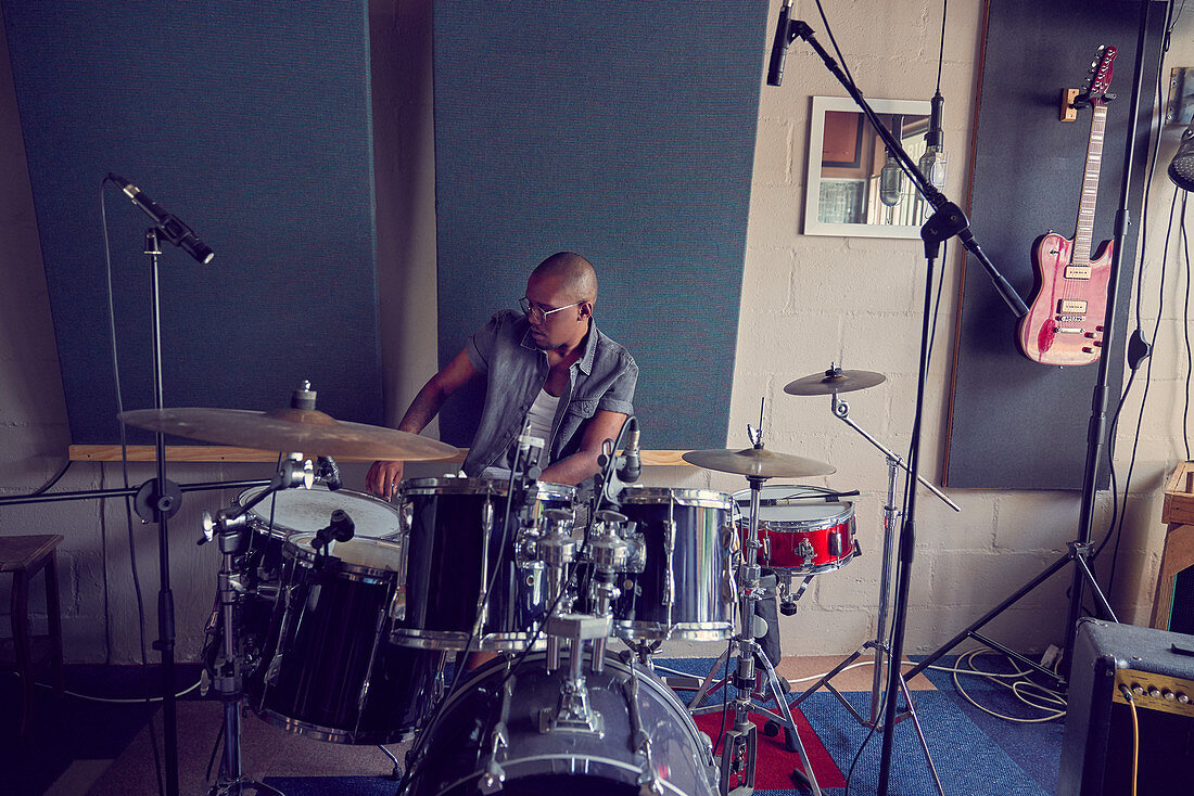 Male drummer practicing in recording studio