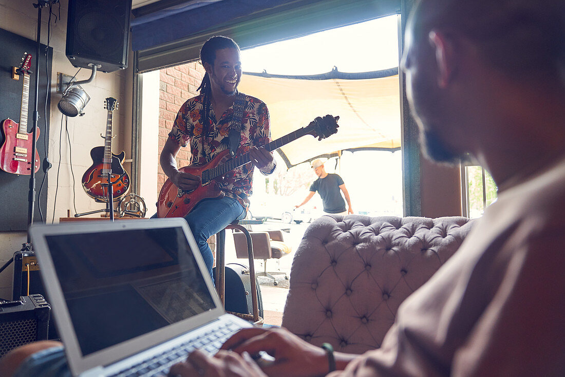 Musicians with laptop and electric guitar