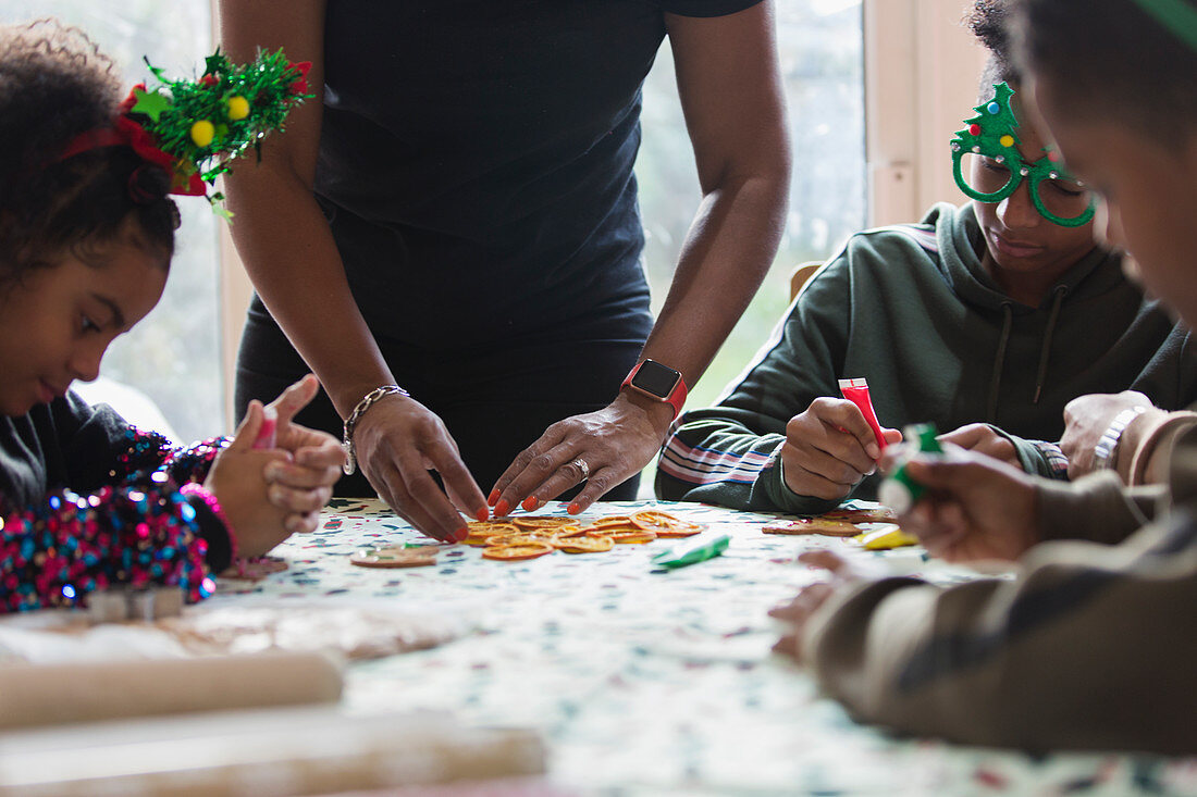 Family decorating Christmas cookies at table