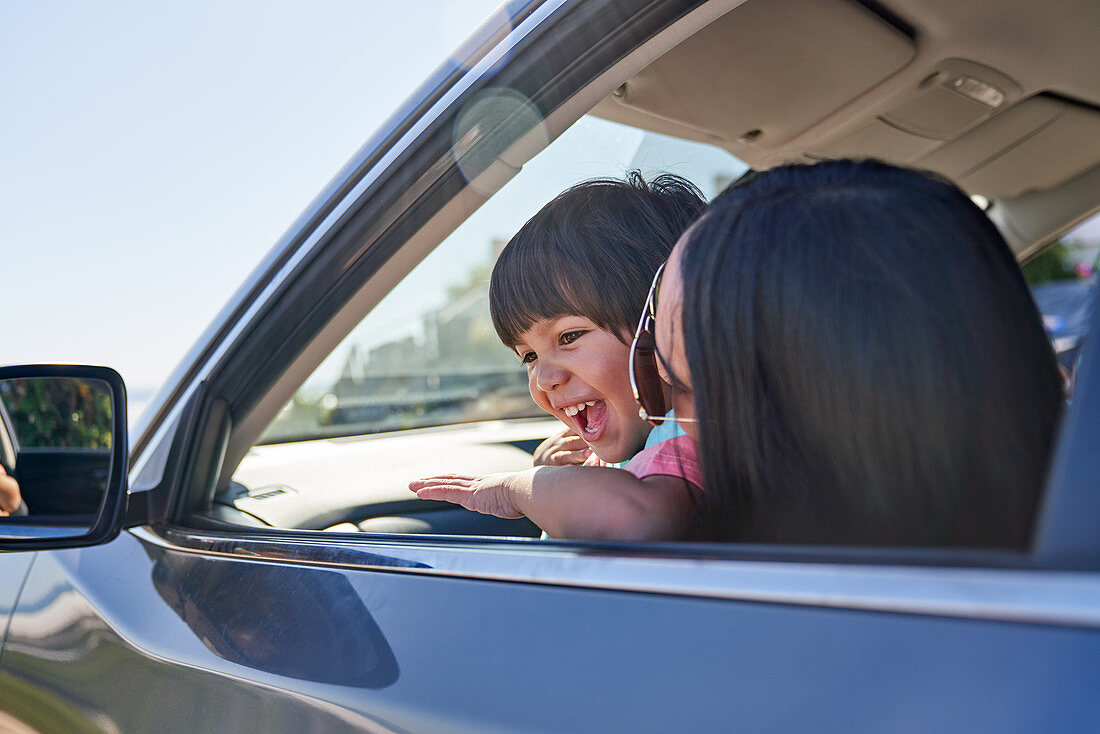 Happy mother and son in sunny car