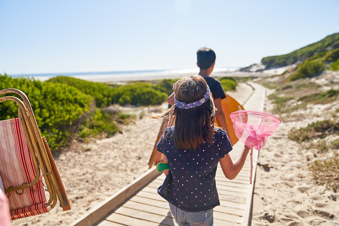 Girl carrying butterfly net on beach boardwalk