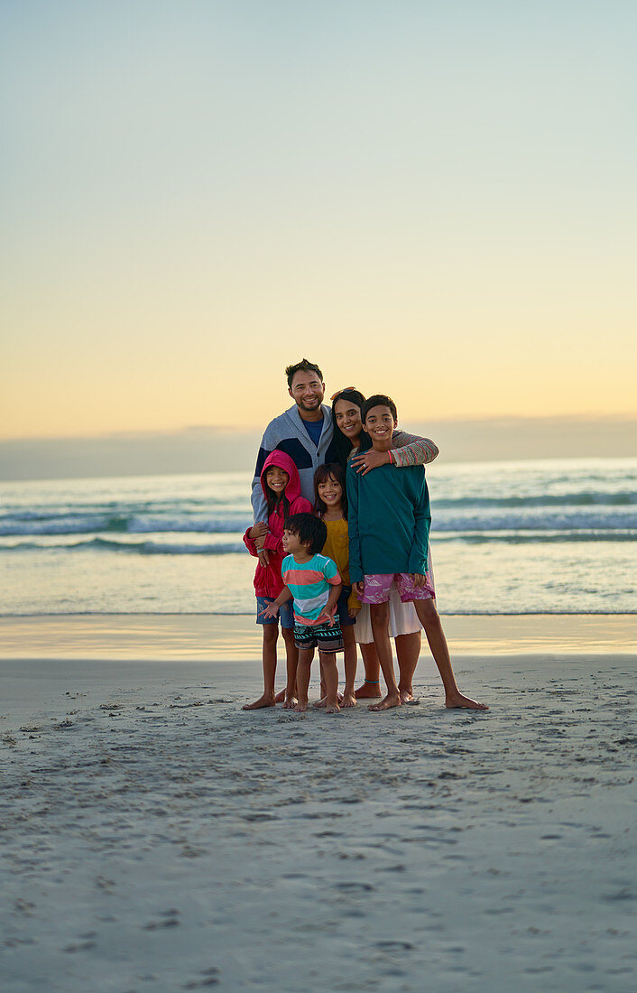 Portrait affectionate family on sunset ocean beach