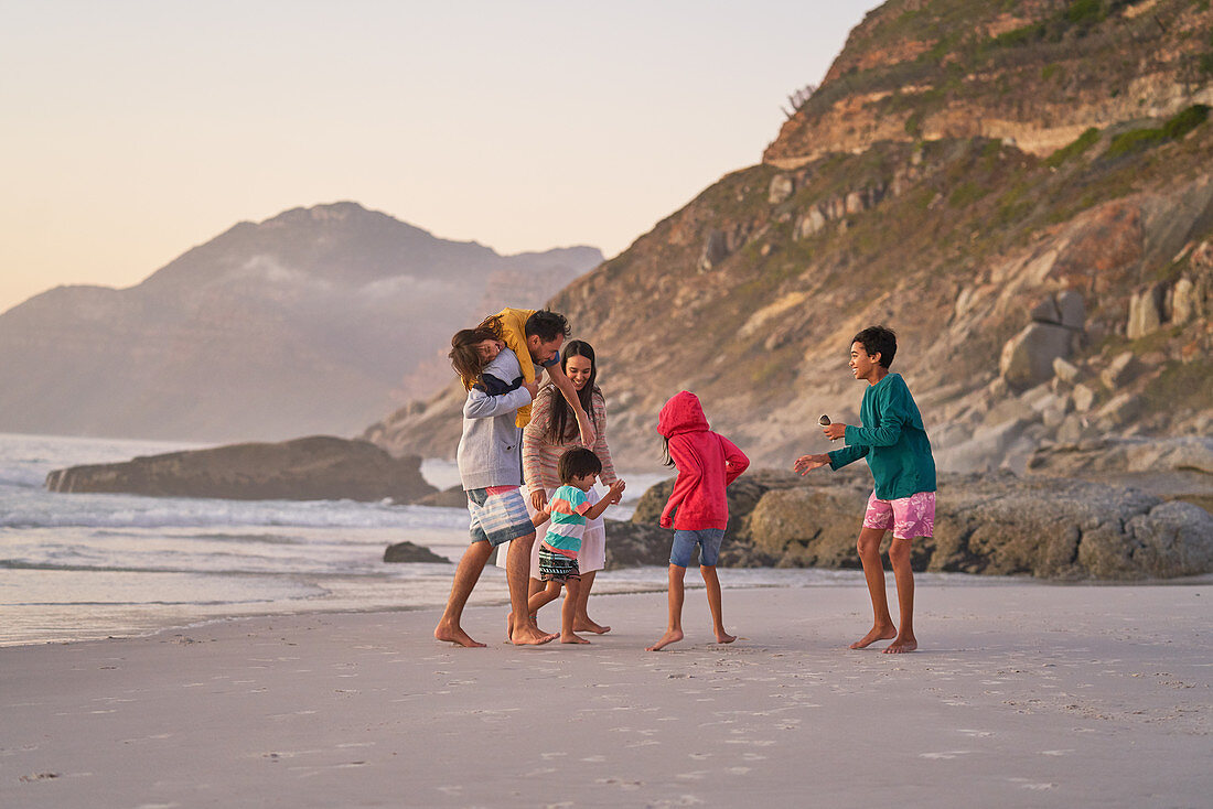 Family playing on ocean beach