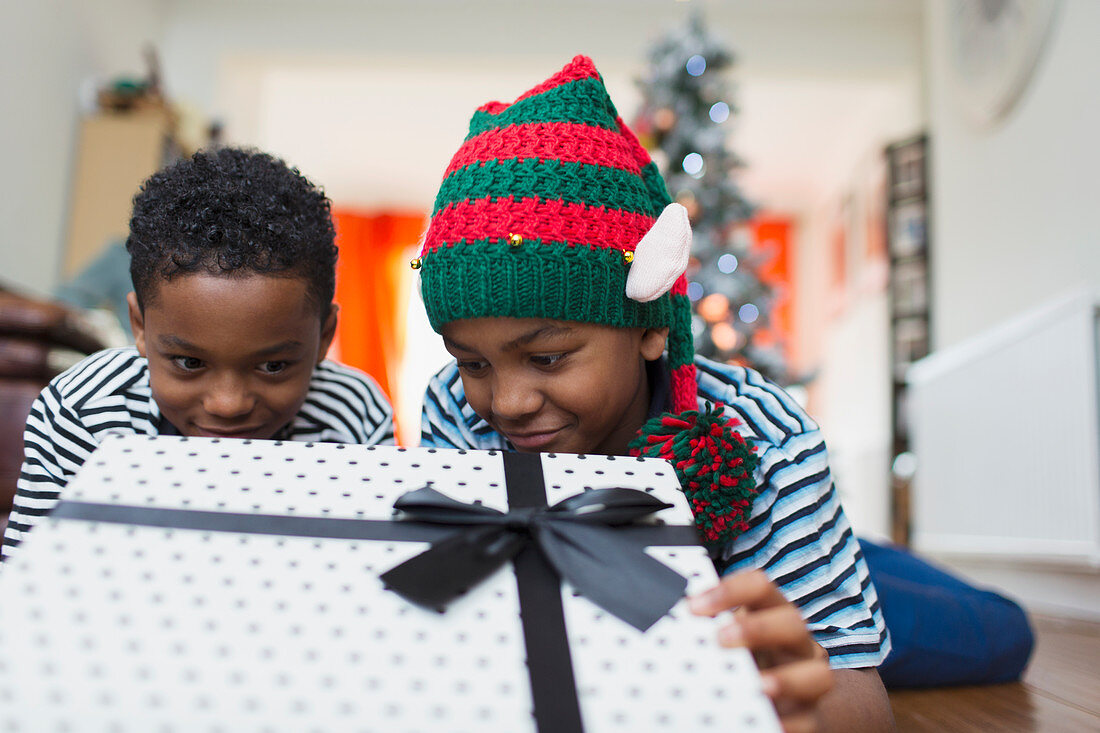 Curious brothers peeking at Christmas gift