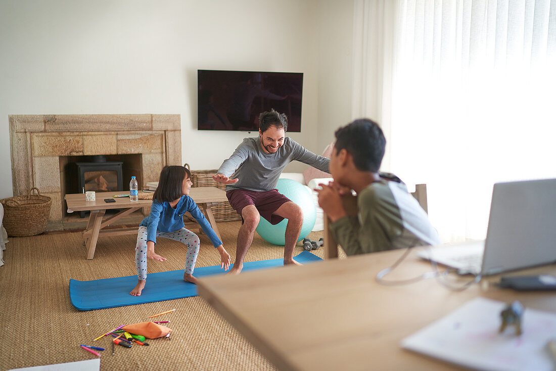 Father and daughter exercising in living room