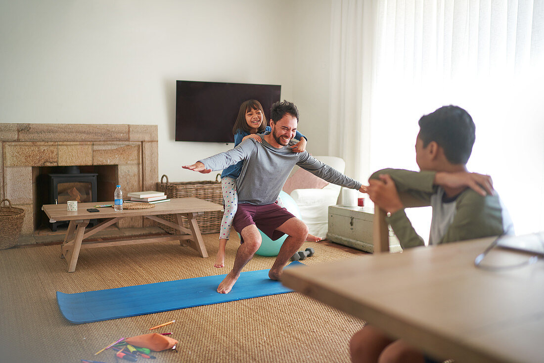 Playful father and daughter exercising