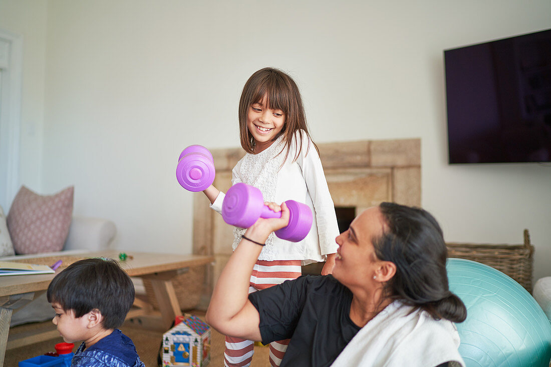 Mother and daughter exercising with dumbbells