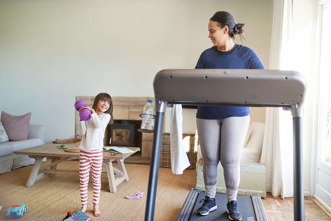 Mother and daughter exercising in living room