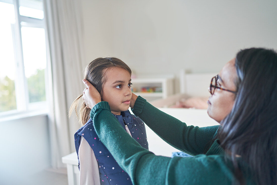 Mother helping daughter fix hair