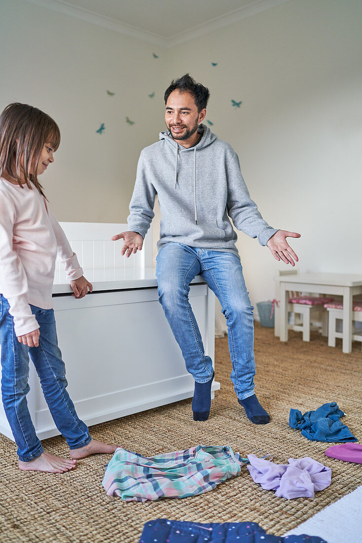 Father helping daughter clean bedroom