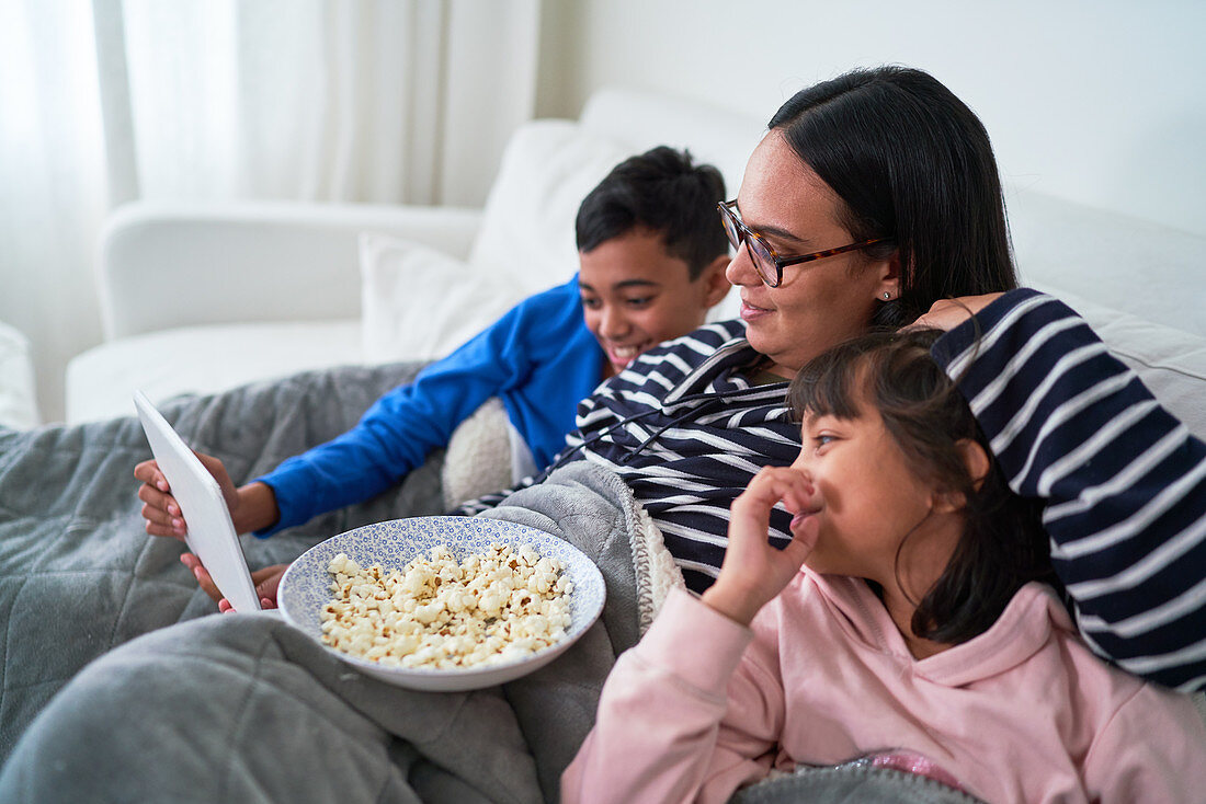 Mother and kids with popcorn watching movie