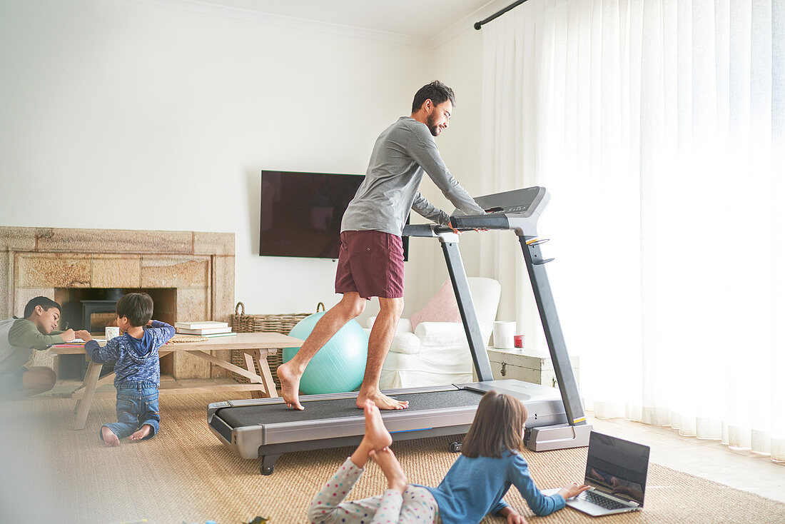 Father exercising on treadmill with kids