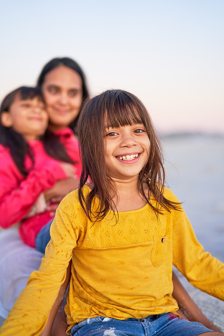 Portrait happy girl relaxing on beach with family