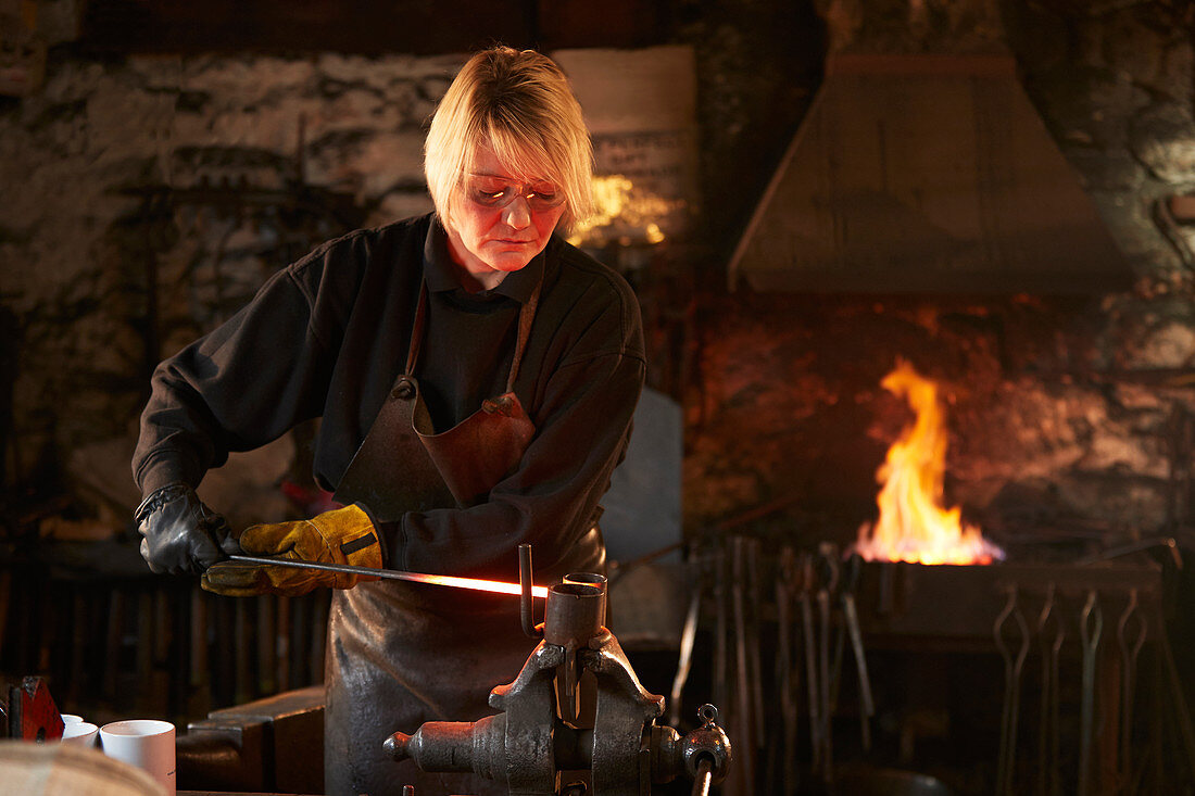 Female blacksmith working in workshop