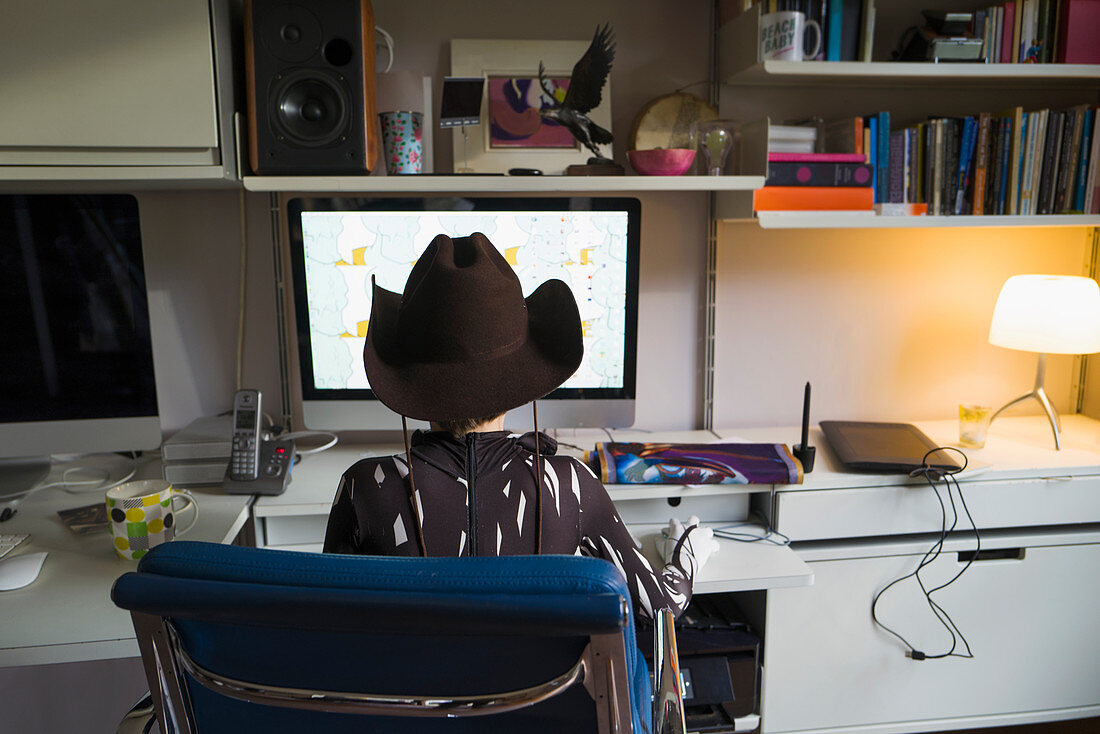 Boy in cowboy hat home schooling at computer