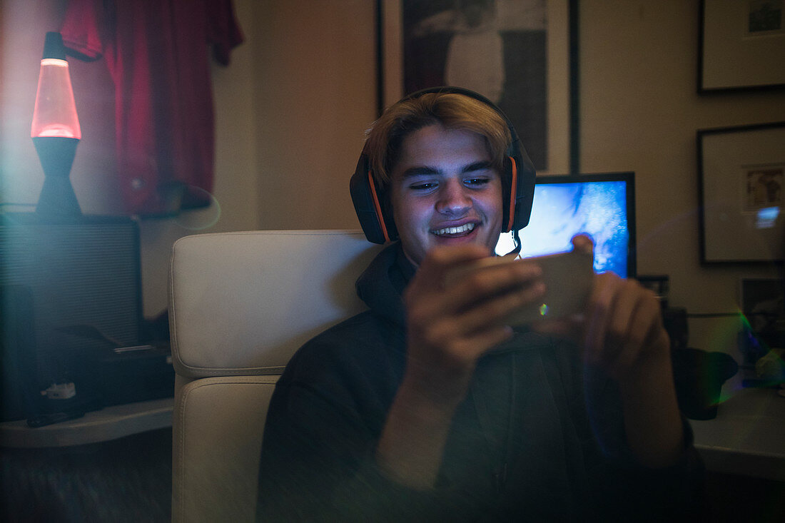 Smiling teenage boy using smart phone