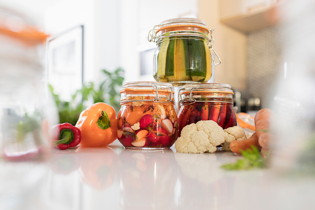 Pickled vegetables in jars on kitchen counter