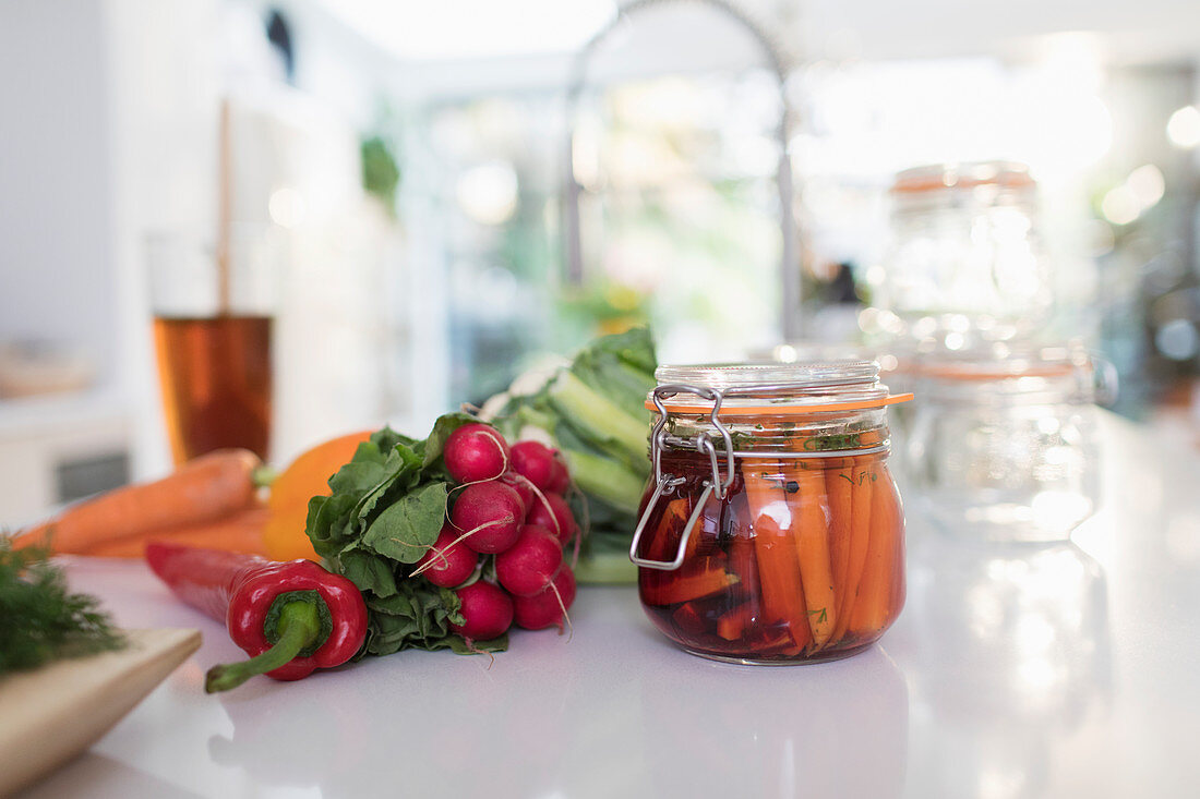 Preserved vegetables in jar on kitchen counter