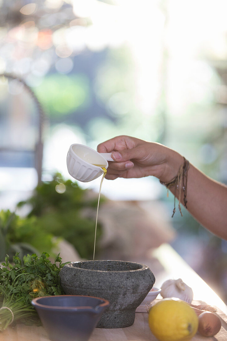 Woman cooking with olive oil and mortar