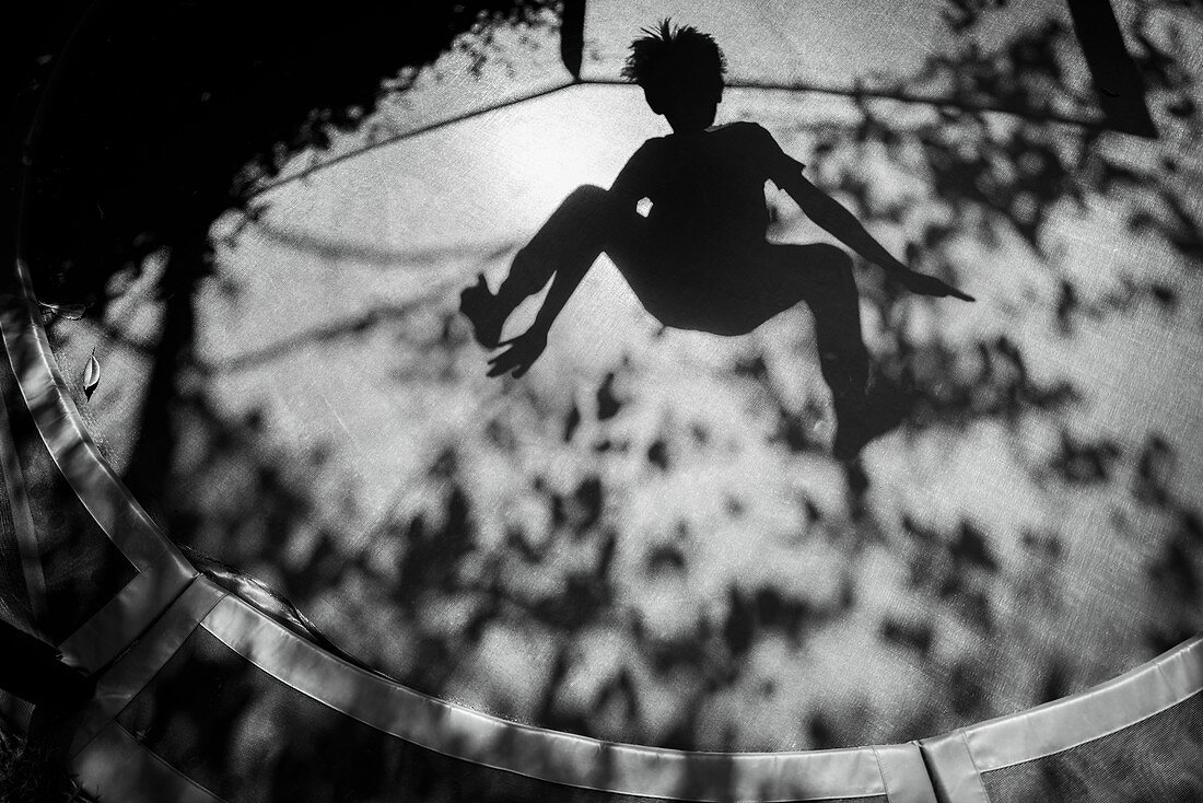 Shadow of boy jumping on trampoline