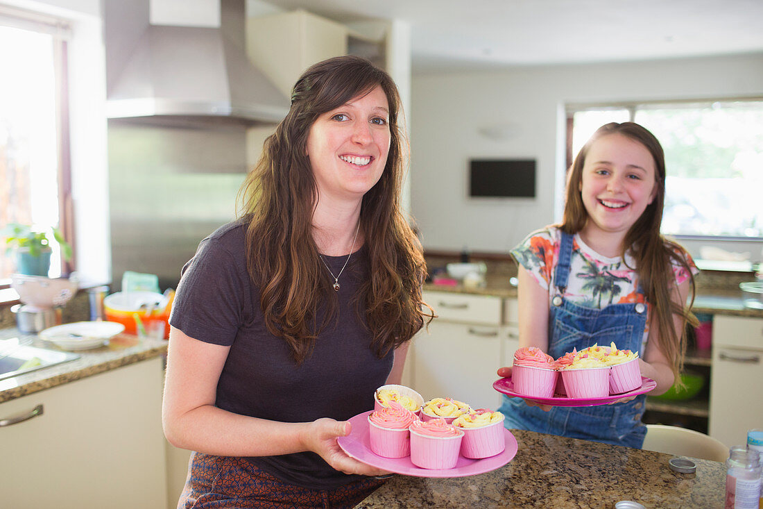 Portrait mother and daughter baking cupcakes