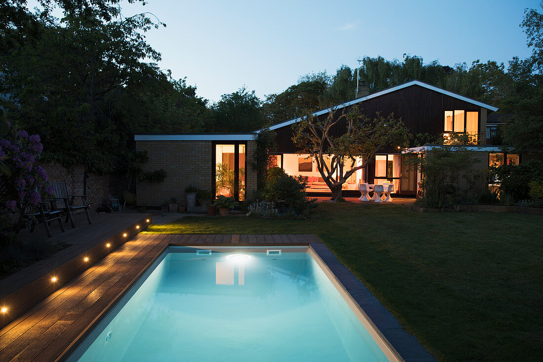 Home showcase exterior with swimming pool at night