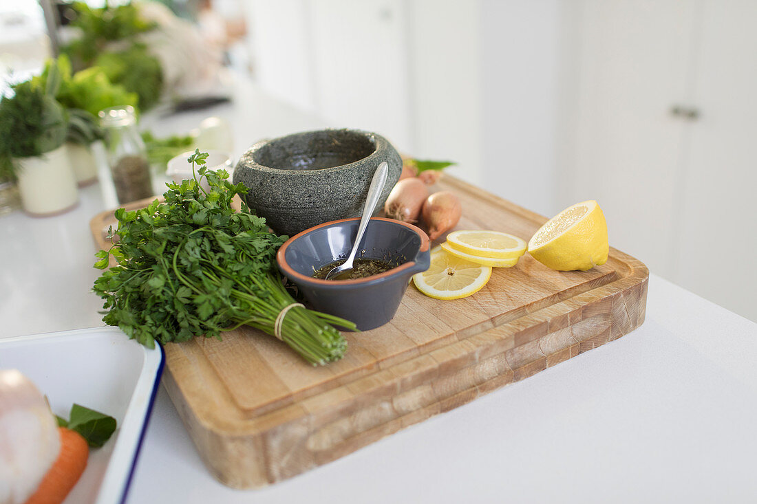 Cilantro and lemons on cutting board with mortar