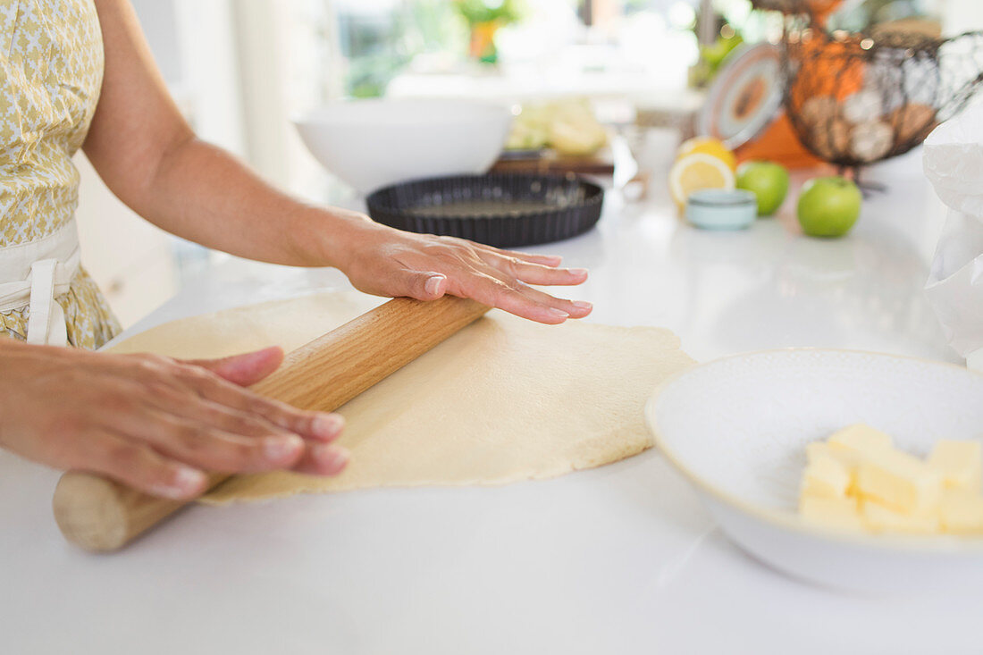 Woman rolling out pie dough with rolling pin