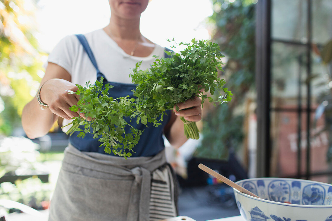 Woman with fresh cilantro cooking