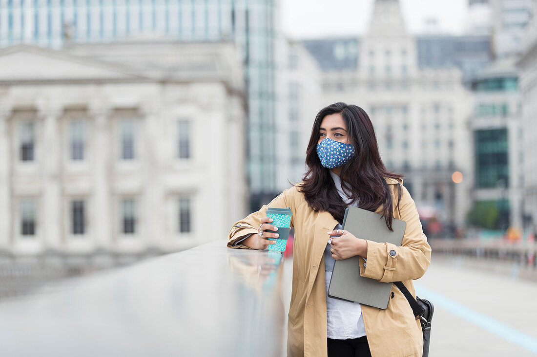 Businesswoman in face mask with coffee