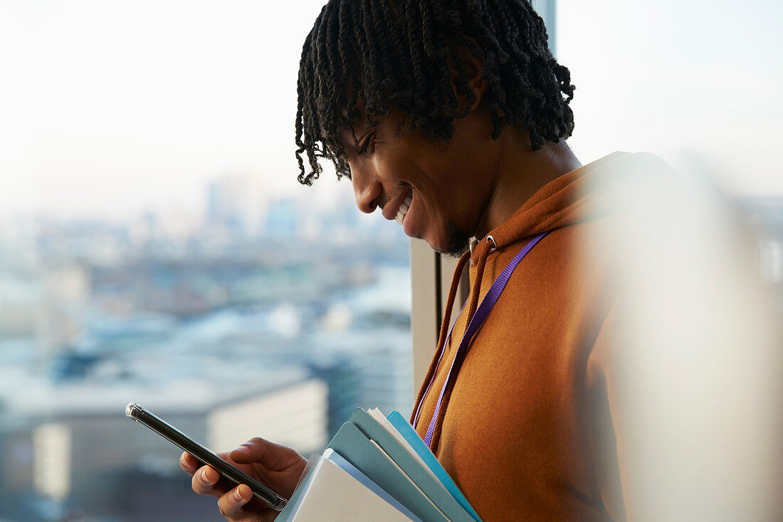 Businessman using smart phone at window