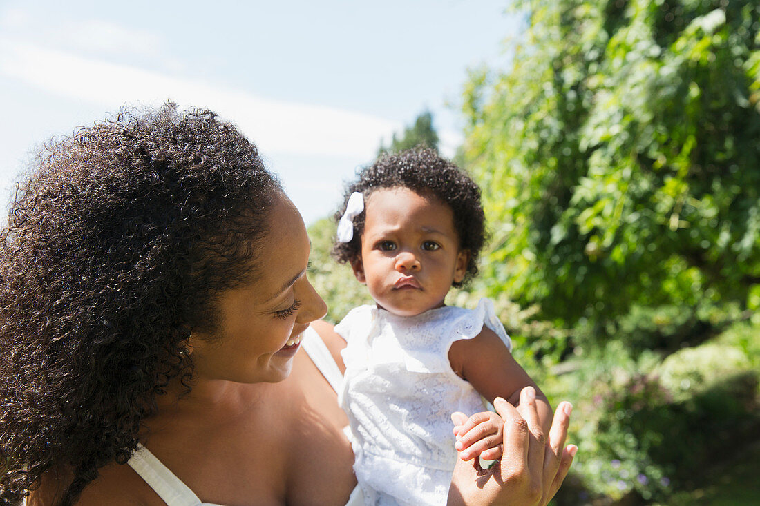 Portrait mother holding toddler daughter