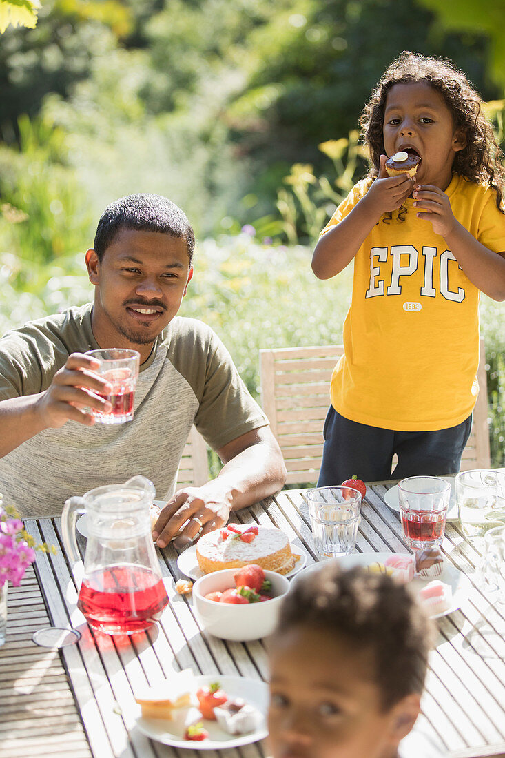 Father and children enjoying garden lunch