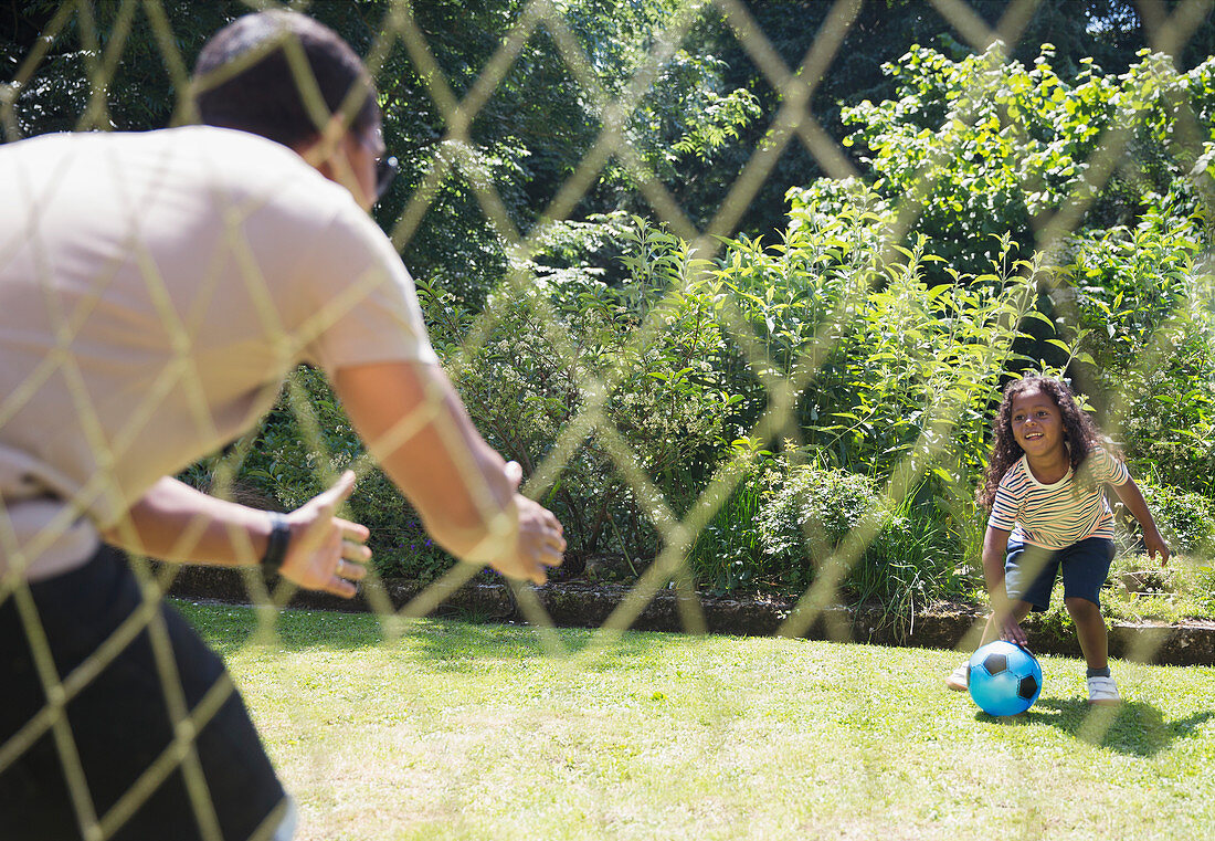 Father and daughter playing soccer