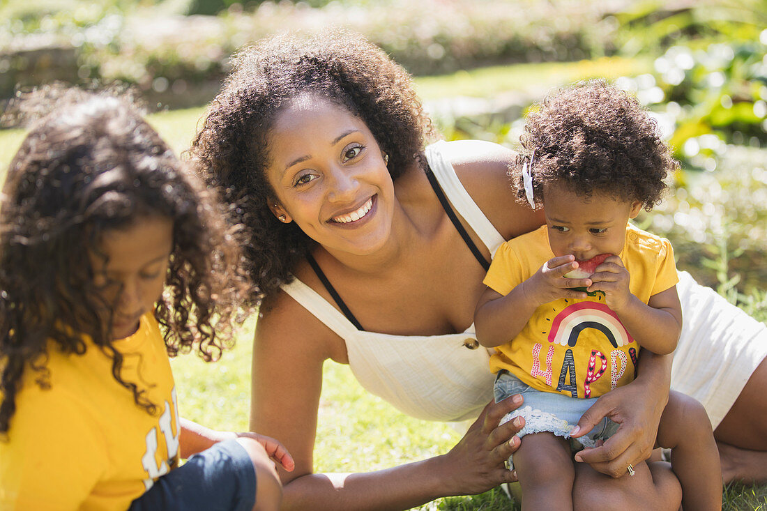 Portrait happy mother and children in summer yard