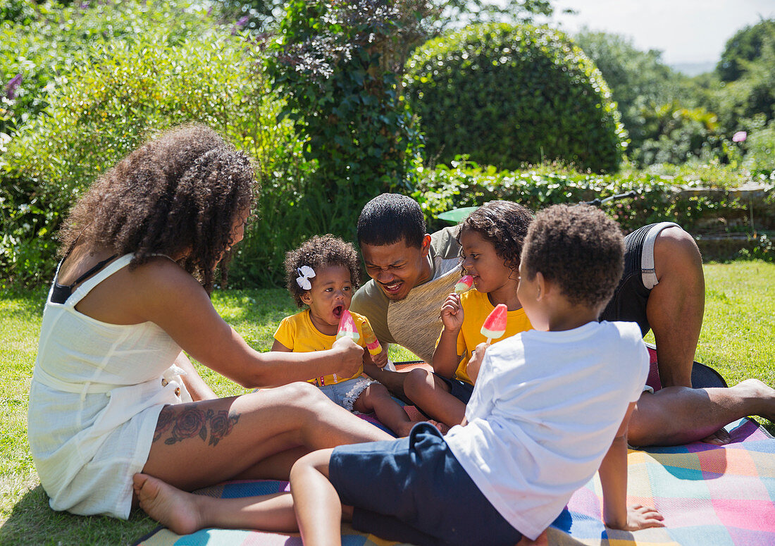 Happy family eating watermelon popsicles