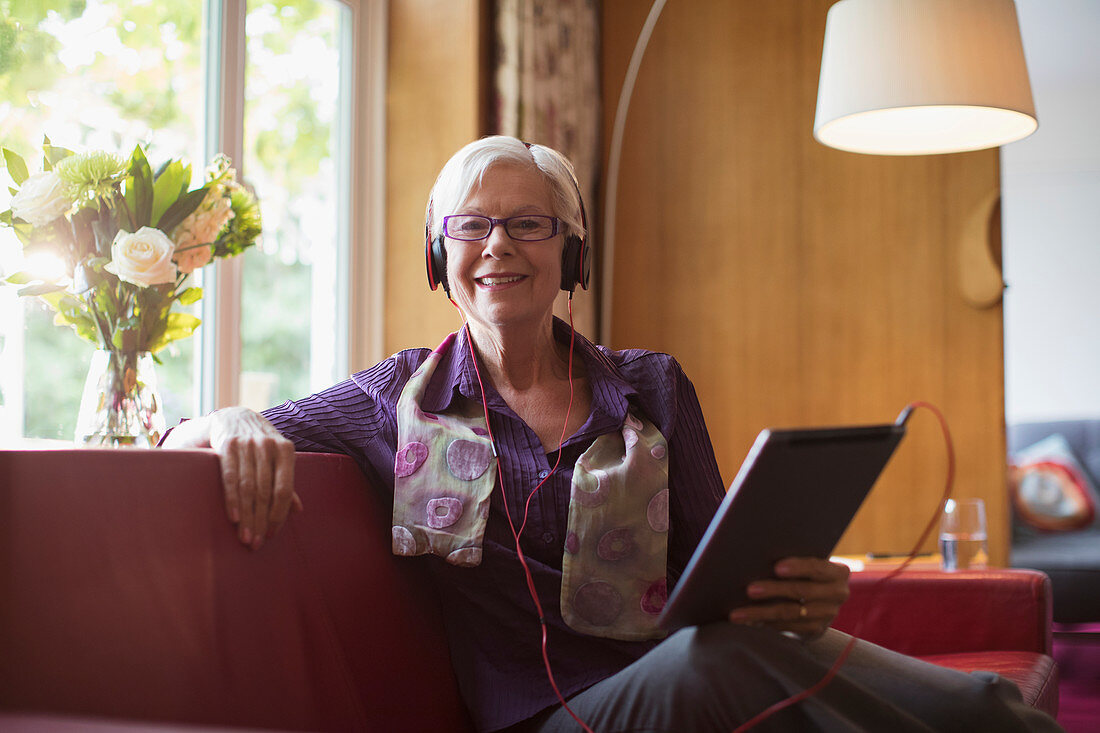 Senior woman and tablet on sofa