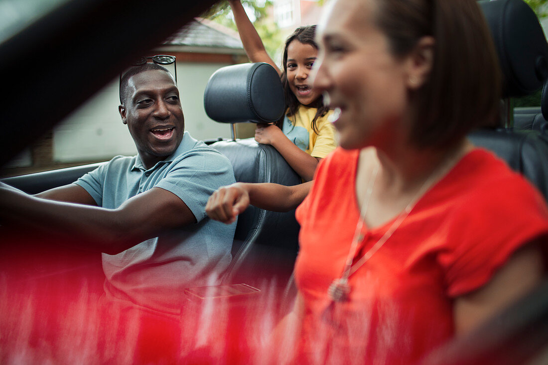 Happy family riding in convertible