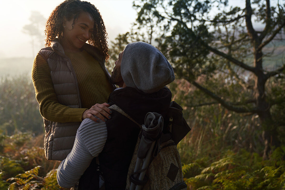 Happy affectionate hiking couple hugging in woods