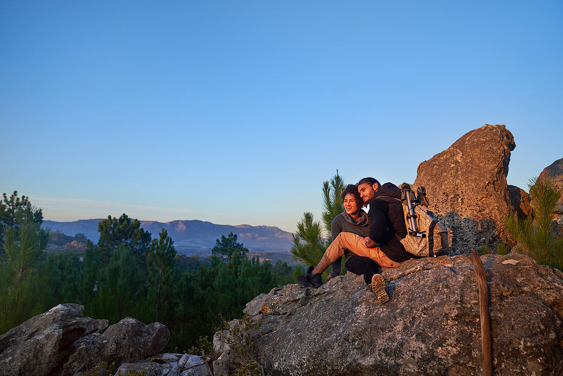 Young hiker couple relaxing and enjoying sunset
