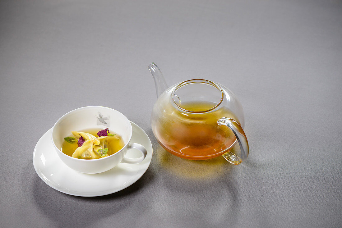 Duck Tea, eisgefiltert mit Pulled-Duck-Ravioli und Shisoblatt