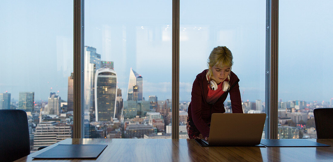 Businesswoman using laptop, London, UK