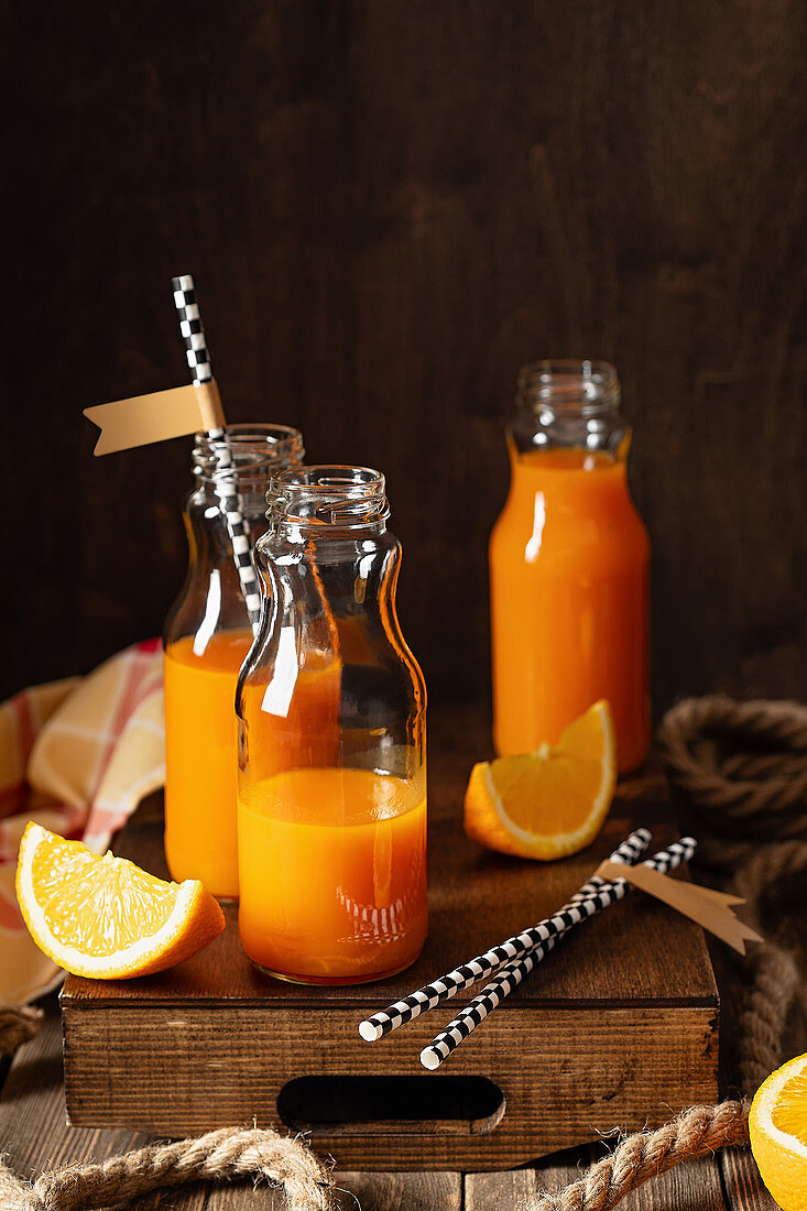 Frischer Vitaminsaft aus Orangen und Karotten in kleinen Flaschen