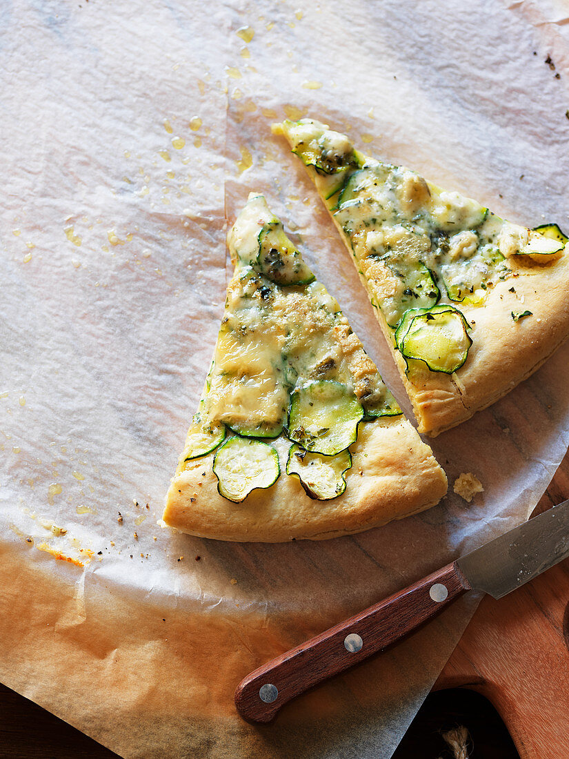 Two pieces of pizza with zucchini and cheese