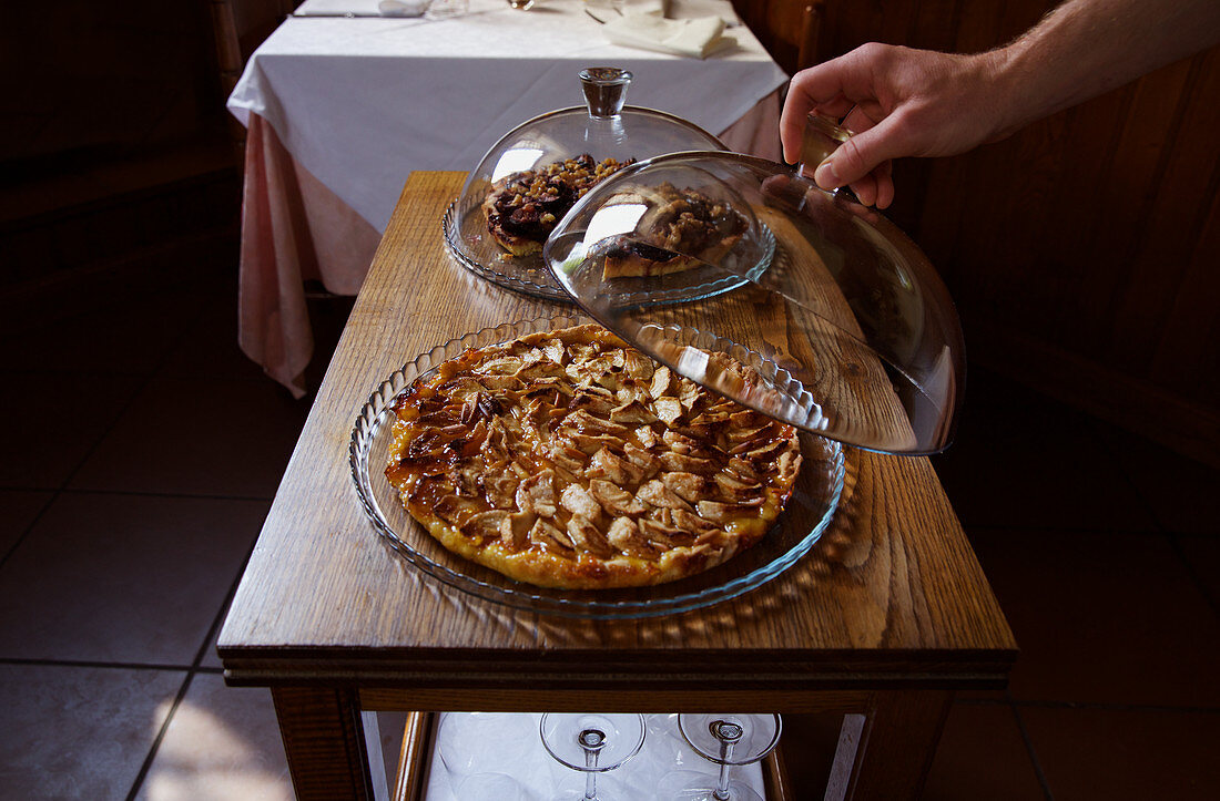 Feigenkuchen unter Glashaube auf Holztisch