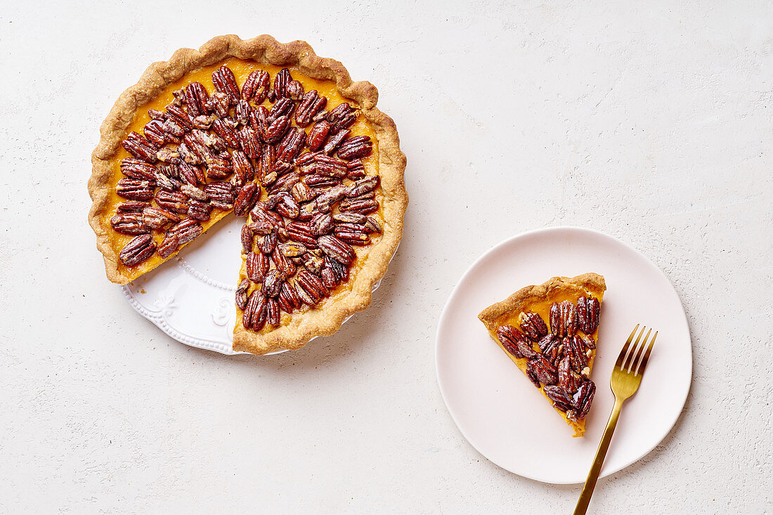 Pecan and pumpkin tart with one slice cut