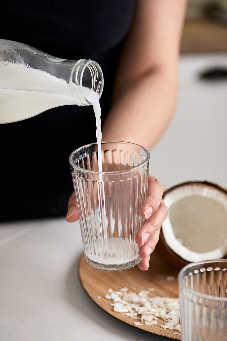 Pouring homemade coconut milk in the glass