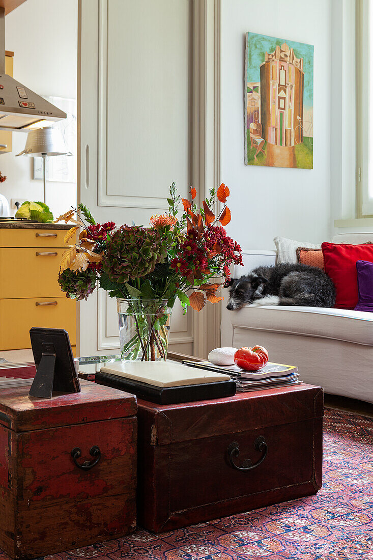 Bouquet of flowers on antique chests used as coffee table in living room