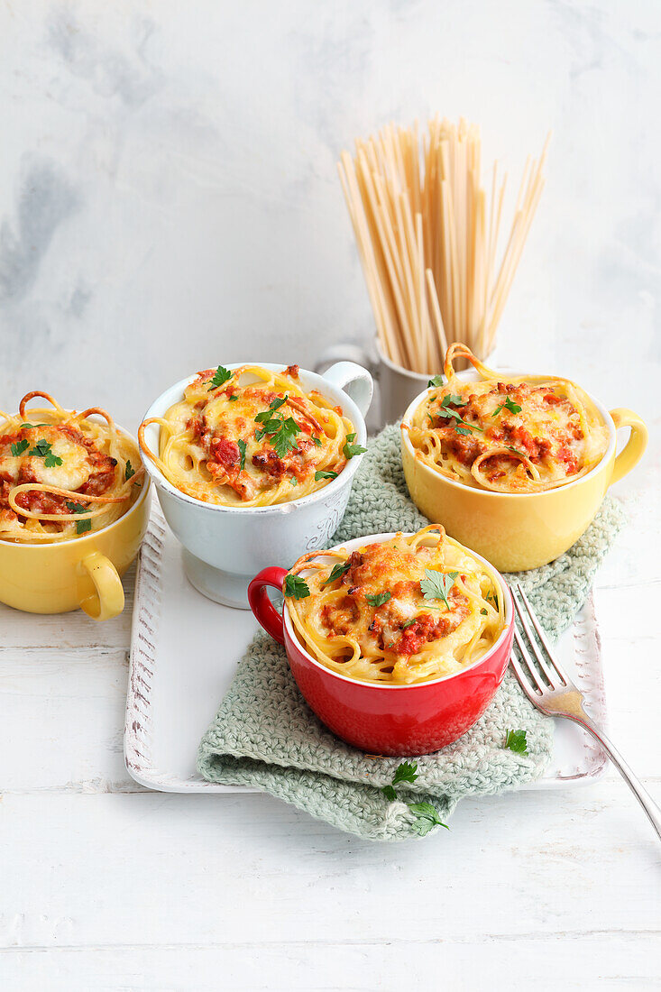Cups filled with pasta and Bolognese sauce
