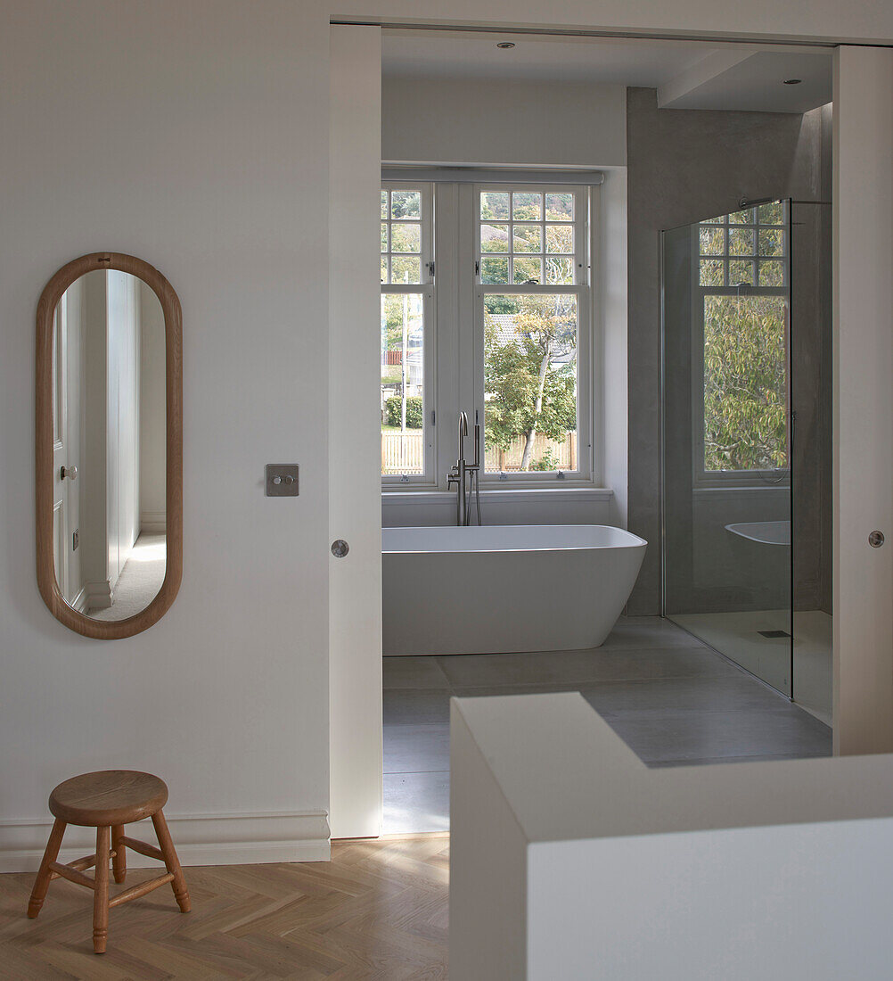 A view into a bathroom with a freestanding bathtub and a shower area